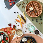 Overhead view of Collarva slow feeder bowls with kibble, wet food, fruit, and enrichment toppings